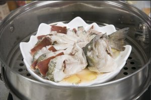 將鱸魚成花狀擺好，將火腿切片放入各縫隙中，放入鍋中隔水蒸12分鐘拿出，撒上蔥花即可。