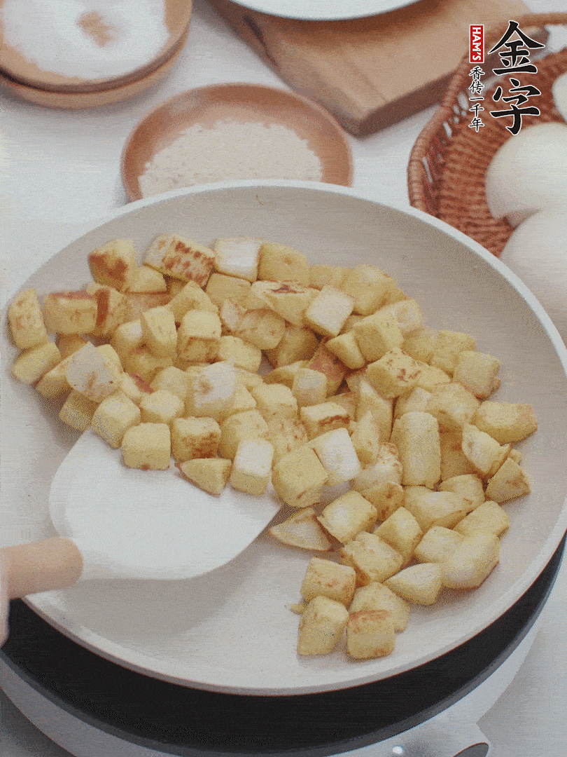 起鍋熱油，倒入饅頭丁，小火煎至蛋液凝固定型再翻面，饅頭丁部煎至金黃時盛起待用。