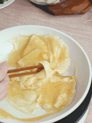 油6成熱時，下雞蛋液，邊緣凝固時翻拌成塊狀。