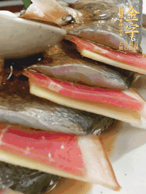 魚肚中塞蔥結(jié)、火腿片，魚身上碼放姜片、火腿片，倒入混合的料汁。
