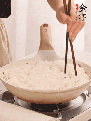 把瀝干水分的米飯均勻鋪在上面，筷子戳幾個(gè)洞，以便透氣，轉(zhuǎn)小火蓋上蓋子燜至水分收干，大概10分鐘。